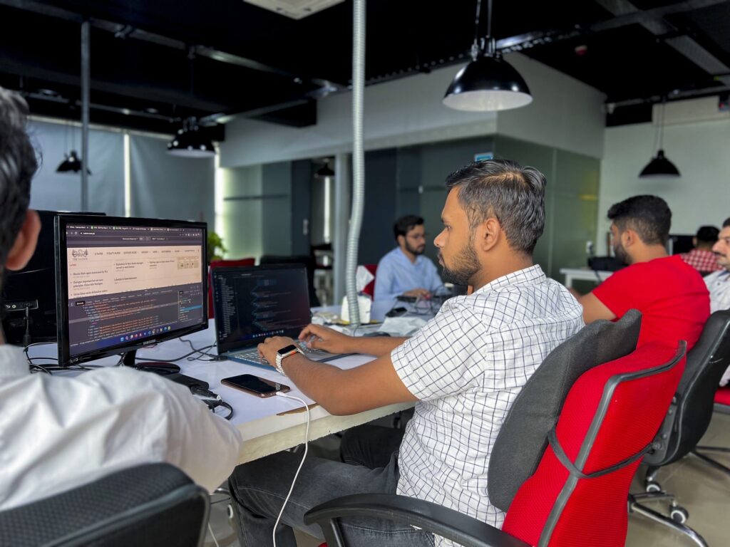 A developer working on his laptop and external monitor at Bramerz Office